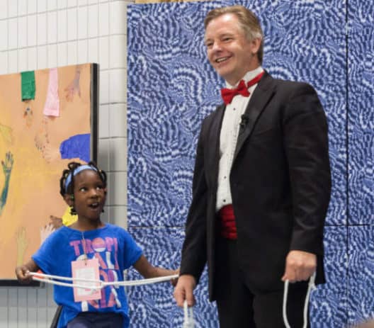 Picture of a young assistant performing magic with Calgary magician Richard Rondeau